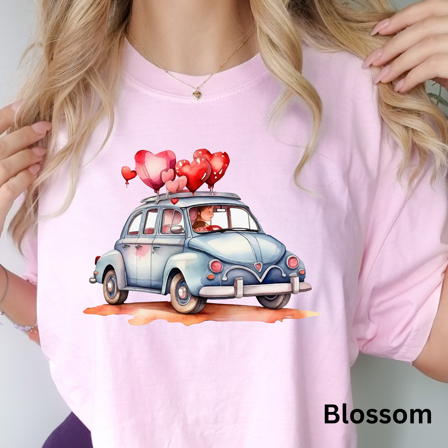 a woman wearing a pink shirt with a car with hearts on it
