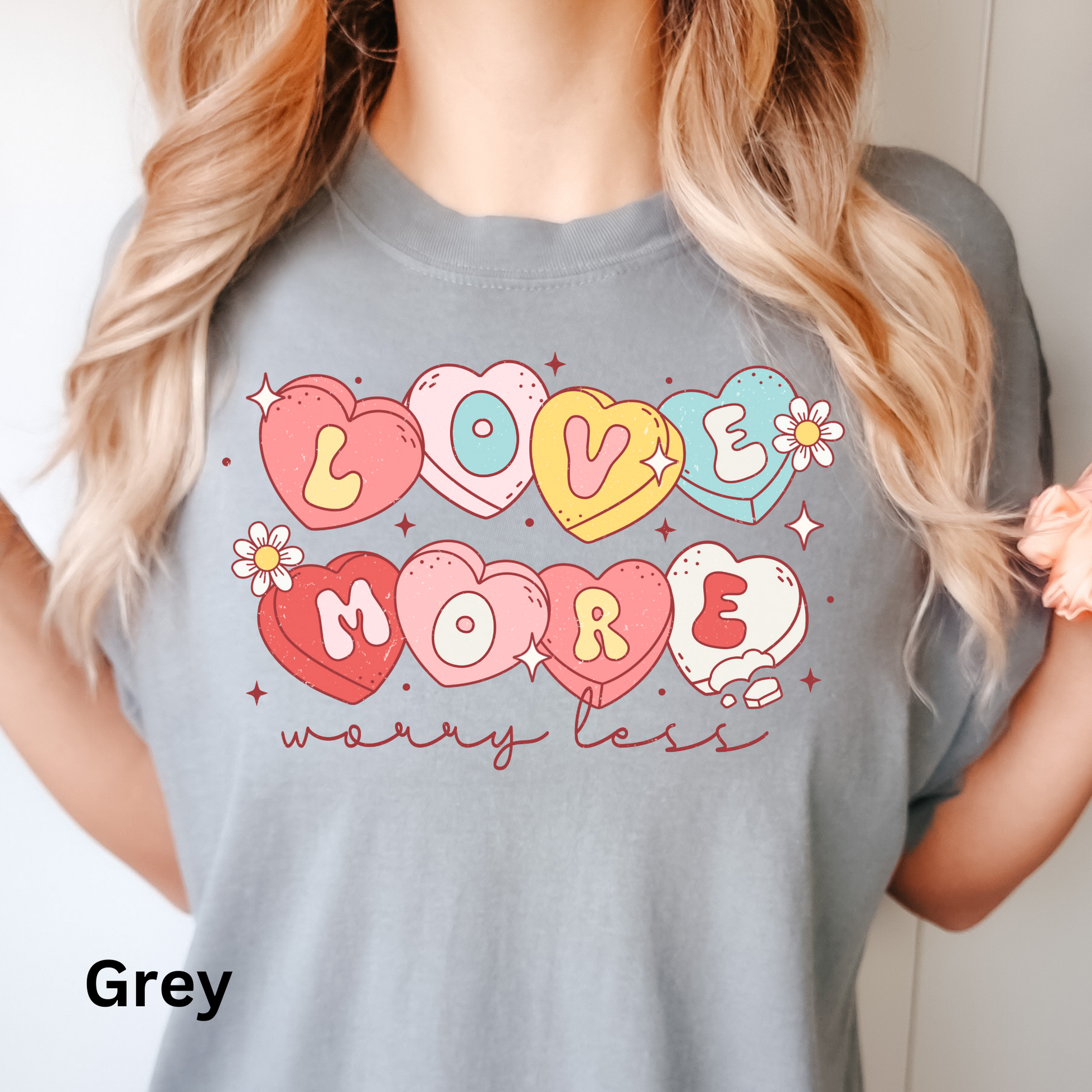 a woman wearing a grey shirt that says love more