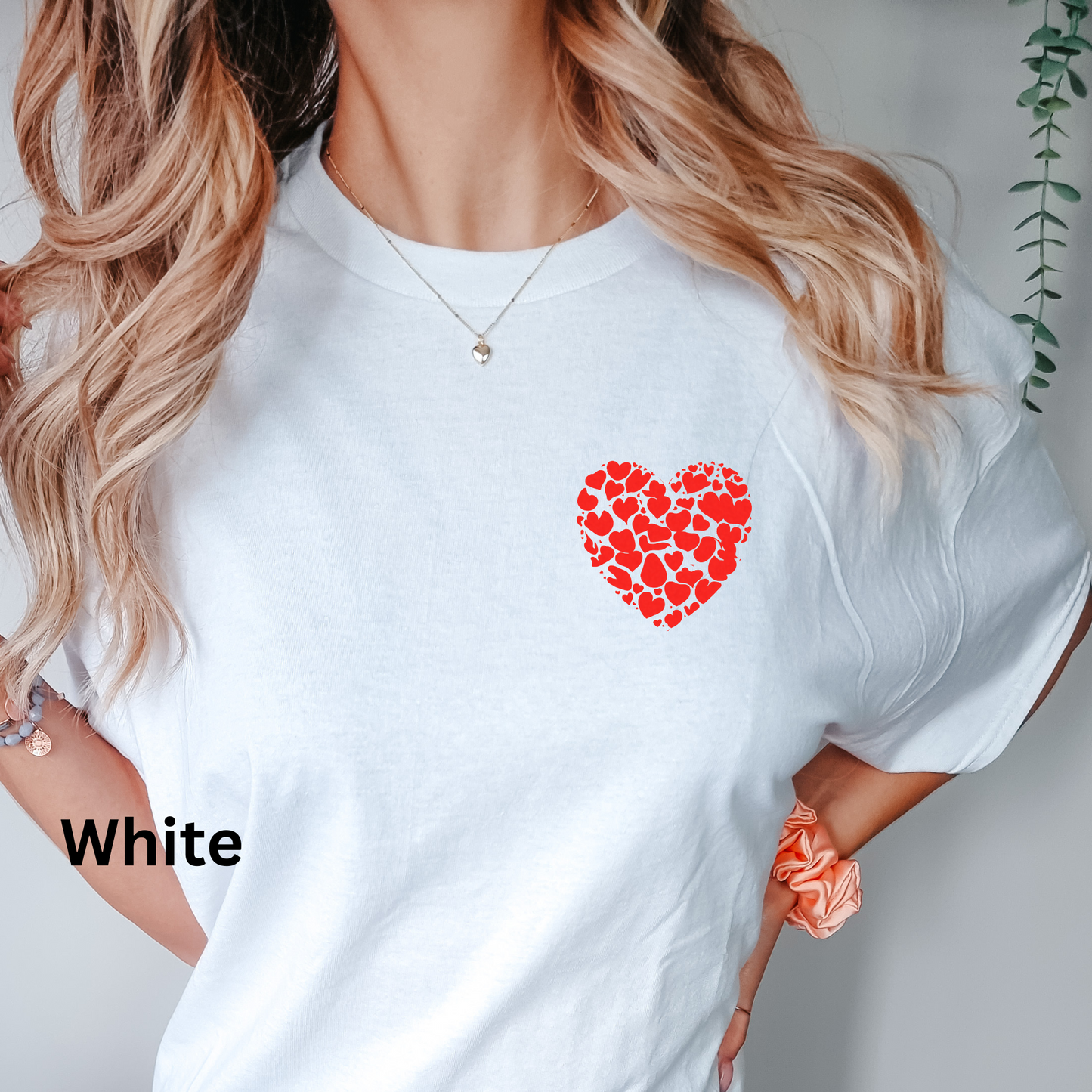 a woman wearing a white shirt with a red heart on it
