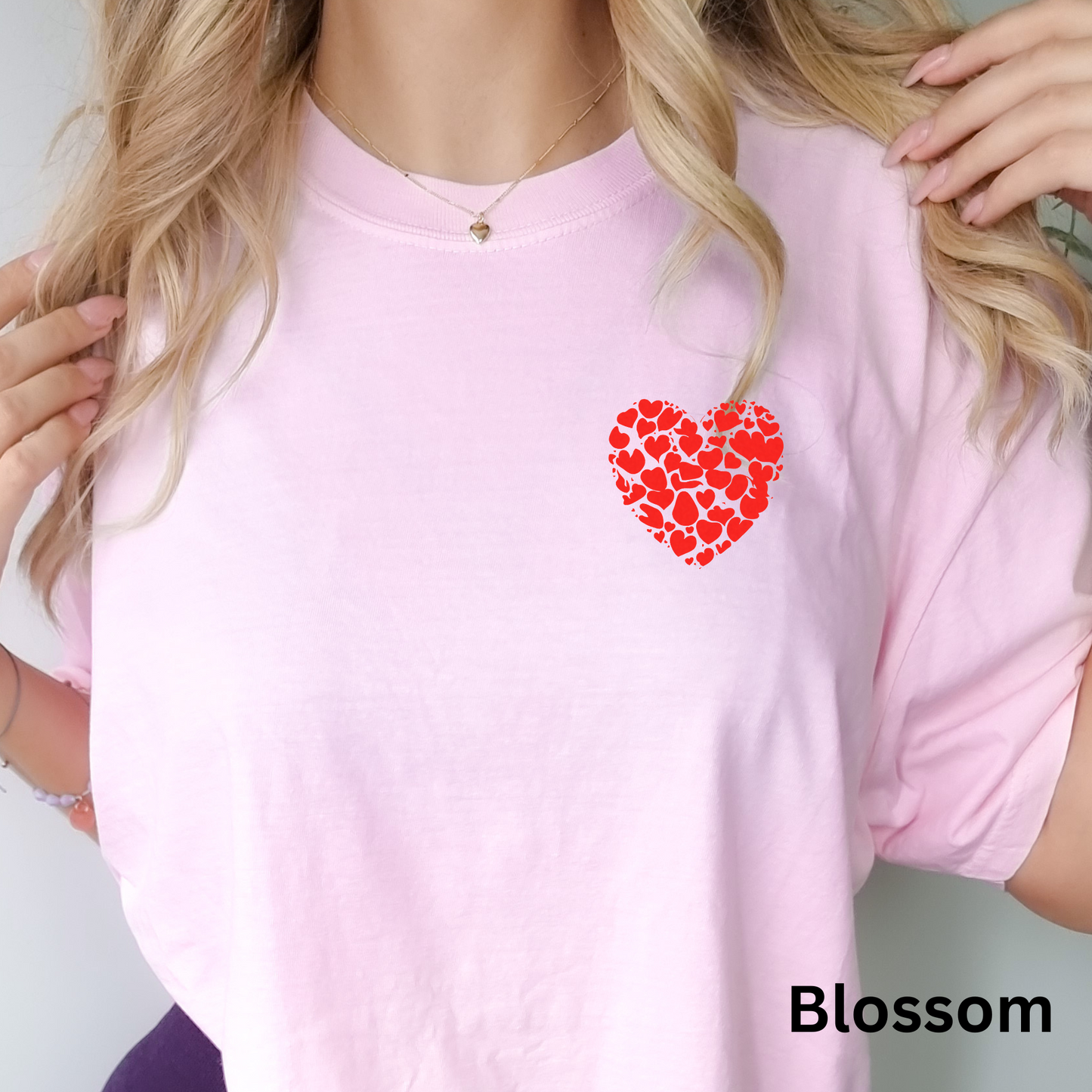 a woman wearing a pink shirt with a red heart on it