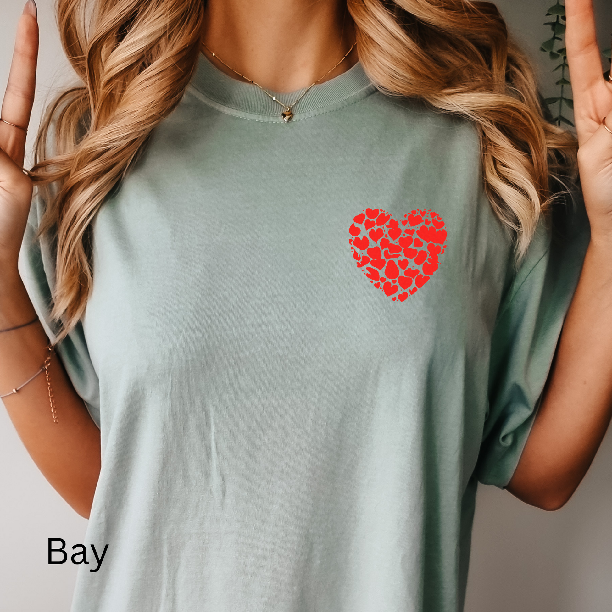 a woman wearing a green shirt with a red heart on it